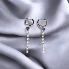 A pair of silver hoop earrings with sapphire blue accents