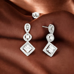 Pair of diamond earrings on a brown fabric background
