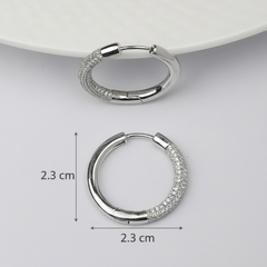 Silver hoop earrings with measurements on a light gray background