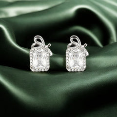 A pair of 925 sterling silver emerald-cut stud earrings with a bow accent and a zircon halo