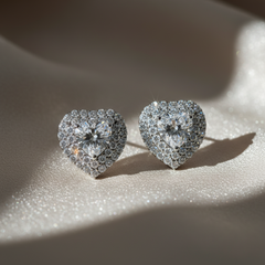 Heart-shaped diamond earrings on a textured surface