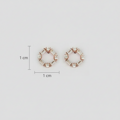 Rose gold earrings with zircon stones accompanied by measurement markers.