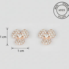 Rose gold flower-shaped earrings with CZ stones on a white background, featuring a 'Real Sterling Silver' stamp.