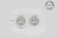 Silver earrings with circular design on a light gray background, featuring 'Real Sterling Silver' stamp.
