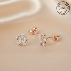 Rose gold flower-shaped earrings with 'Real Sterling Silver' 925 stamp.