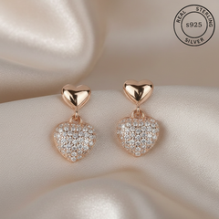 Heart-shaped earrings with rose gold and AAA+ CZ diamonds, featuring 'Real Sterling Silver' certification.