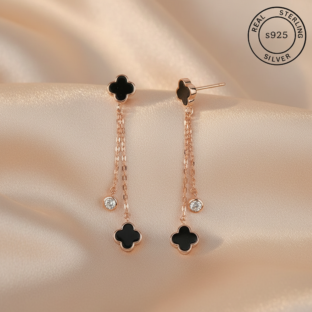 Pair of black clover-shaped earrings with rose gold chains featuring 'Real Sterling Silver' certification.