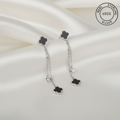Silver earrings with black clover-shaped tops featuring 'Real Sterling Silver' label.