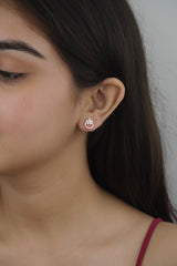 A person wearing 925 sterling silver rose gold bloom stud earrings with zircon stones.