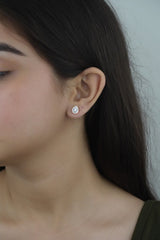 A person wearing 925 sterling silver rose gold teardrop stud earrings.
