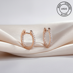 Rose gold hoop earrings with AAA+ CZ on a beige fabric background, featuring 'Real Sterling Silver 925' stamp.
