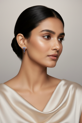 Woman wearing a silver earring against a neutral background