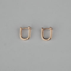 Pair of rose gold hoop earrings on a gray background