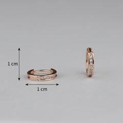 Rose gold hoop earrings with clear gemstones on a gray background, showing size measurement.