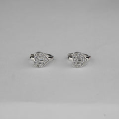 Heart-shaped silver earrings on a gray background
