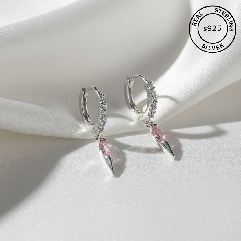 Silver hoop earrings with pink gemstones on a white surface, featuring 'Real Sterling Silver' label.