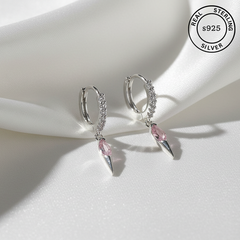 Silver hoop earrings with pink gemstones on a white surface, featuring 'Real Sterling Silver' label.