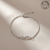 Silver bracelet with infinity symbol on a beige background, featuring 'Real Sterling Silver' stamp.