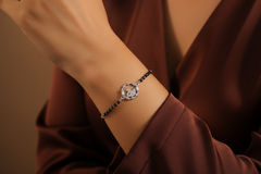 925 Sterling Silver Swan Black Bead Bracelet with a decorative clasp on a wrist against a brown background