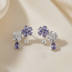 Pair of earrings with purple gemstones on a beige background