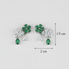 Pair of earrings with green gemstones and clear stones on a light gray background