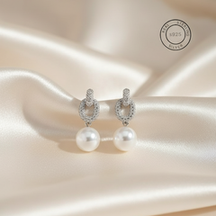 Silver Pearl Drop Dangles
with silver hooks on a satin background, featuring 'Real Sterling Silver' text.