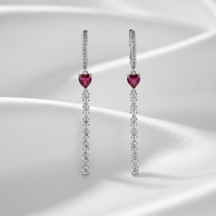 Pair of earrings with heart-shaped gemstones on a white background