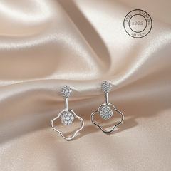 Silver earrings with gemstones on a satin background, featuring a 'Real Sterling Silver' stamp.