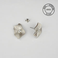Silver leaf-shaped earrings on a light gray background with 'Real Sterling Silver' stamp.