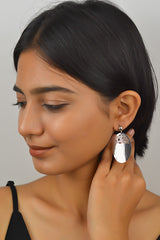 A woman wearing 925 sterling silver oval dangle earrings with a sleek and minimalistic design.