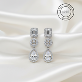 Silver earrings with AAA+ Cubic Zircons on a satin background, featuring 'Real Sterling Silver' label.