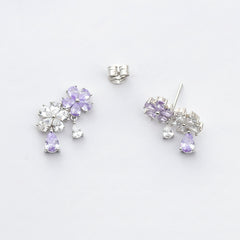 Pair of silver earrings with purple gemstones on a white background