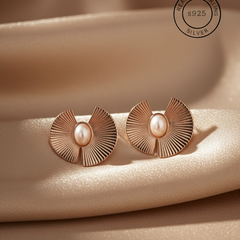 Rose gold earrings with pearl center on beige fabric, featuring '925 Sterling Silver' stamp.