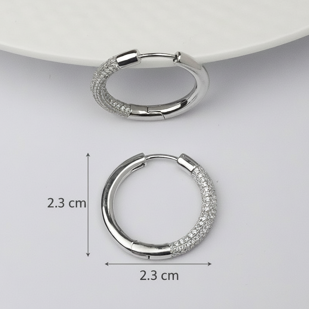 Silver hoop earrings with measurements on a light gray background