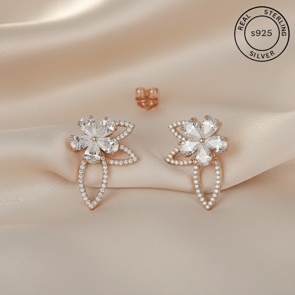 Pair of silver earrings with floral design featuring 'Real Sterling Silver' stamp.