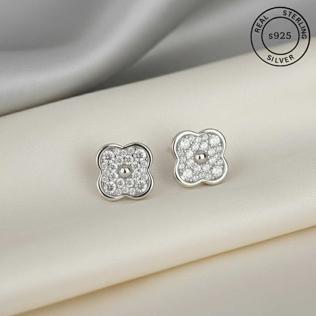 Silver clover-shaped earrings with AAA+ Zircon stones , featuring 'Real Sterling Silver' stamp.