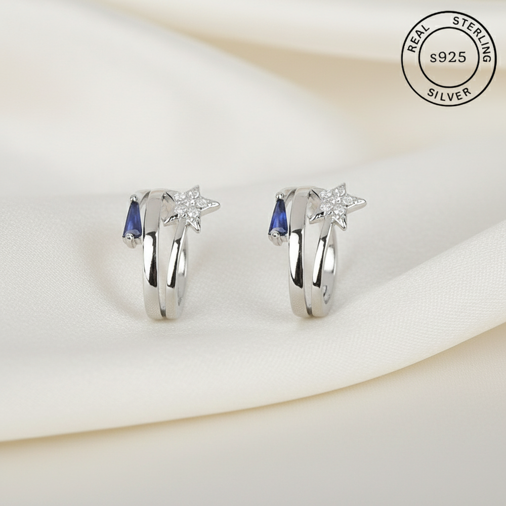 Pair of silver earrings with blue stones & star  featuring 'Real Sterling Silver' label.