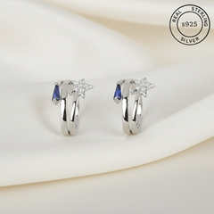 Pair of silver earrings with blue stones & star  featuring 'Real Sterling Silver' label.