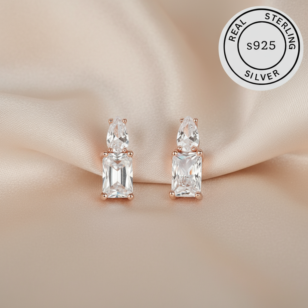 Pair of silver earrings with rose gold accents  featuring a 'Real Sterling Silver S925' label.