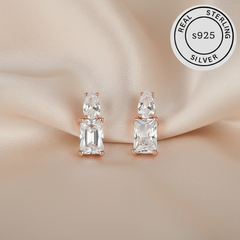 Pair of silver earrings with rose gold accents  featuring a 'Real Sterling Silver S925' label.