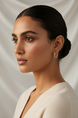 Woman with a stylish hair bun wearing 925 Sterling Silver Rosegold Twist Hoop Earrings