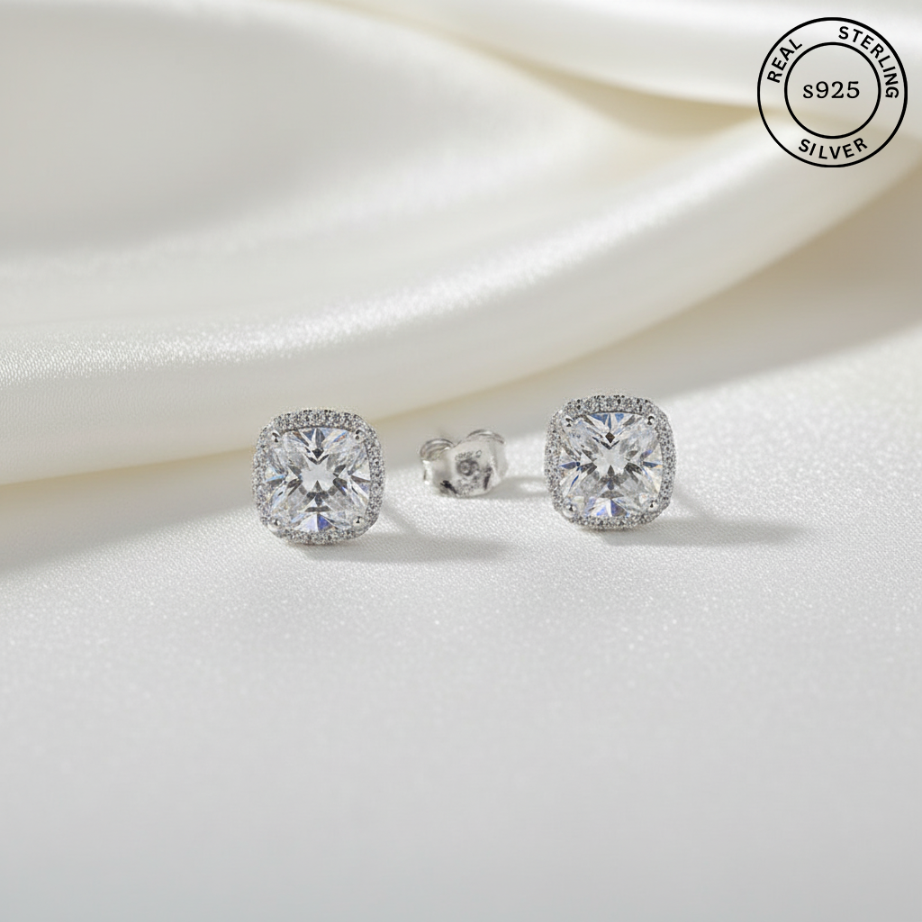 Silver earrings with AAA+ gemstones on a white fabric background, featuring 'Real Sterling Silver' label.