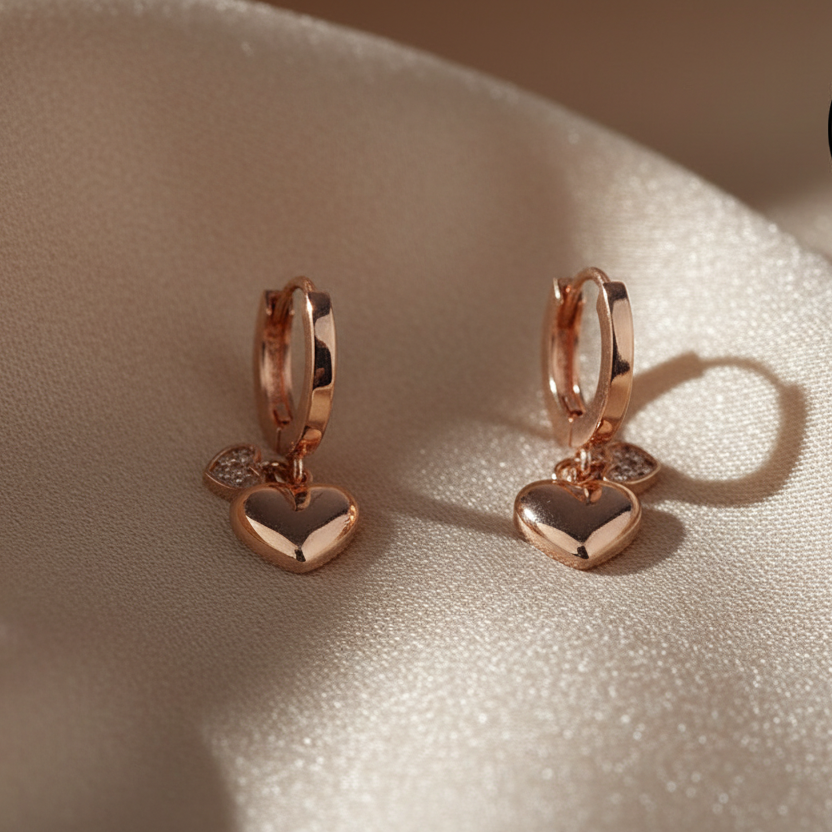 Rose gold hoop earrings with heart-shaped charms 