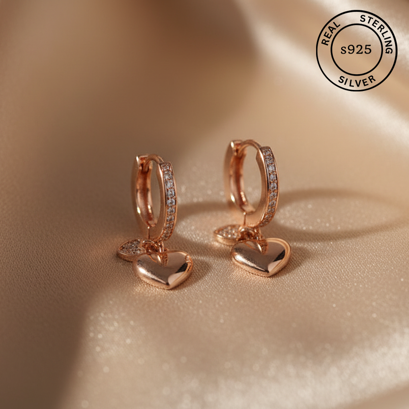 Rose gold hoop earrings with heart pendants featuring 'Real Sterling Silver 925' stamp.