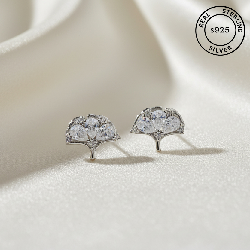Silver earrings with AAA+ Zircons on a light background, featuring 'Real Sterling Silver s925' label.