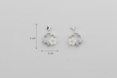 Pair of floral earrings with measurements on a gray background