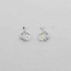 Pair of silver hoop earrings with floral designs on a light gray background