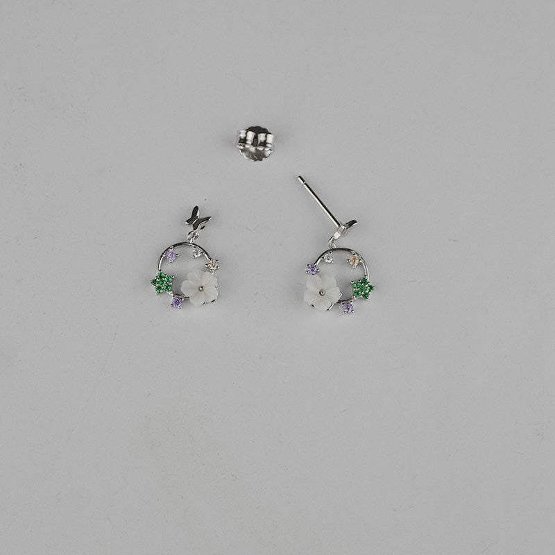 Pair of earrings with floral design on a gray background