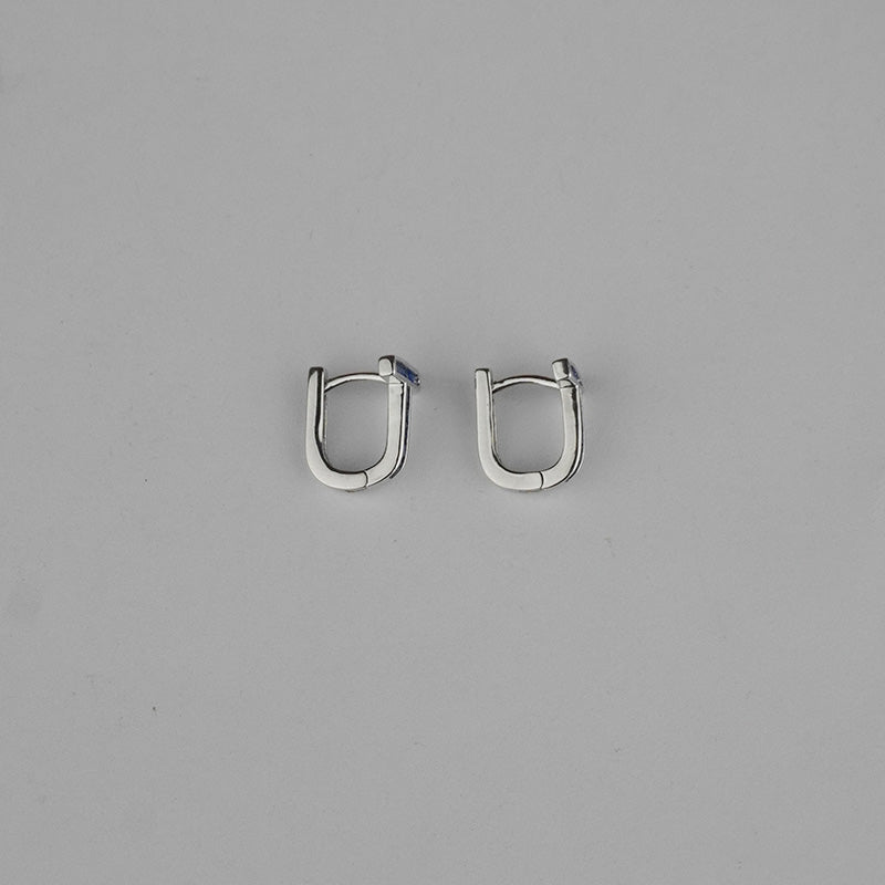 Pair of silver hoop earrings on a gray background