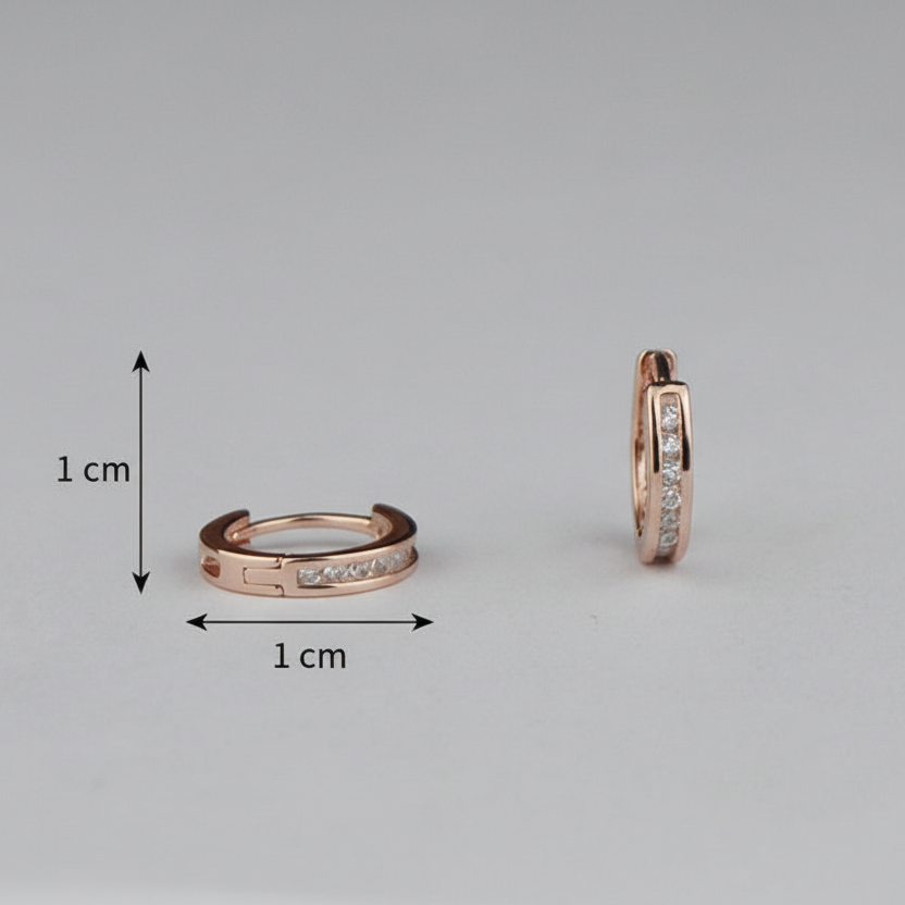 Rose gold hoop earrings with clear gemstones on a gray background, showing size measurement.